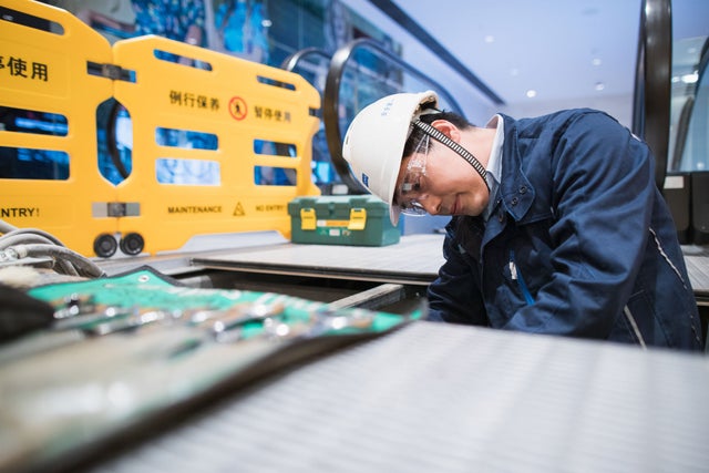KONE technician working on an escalator