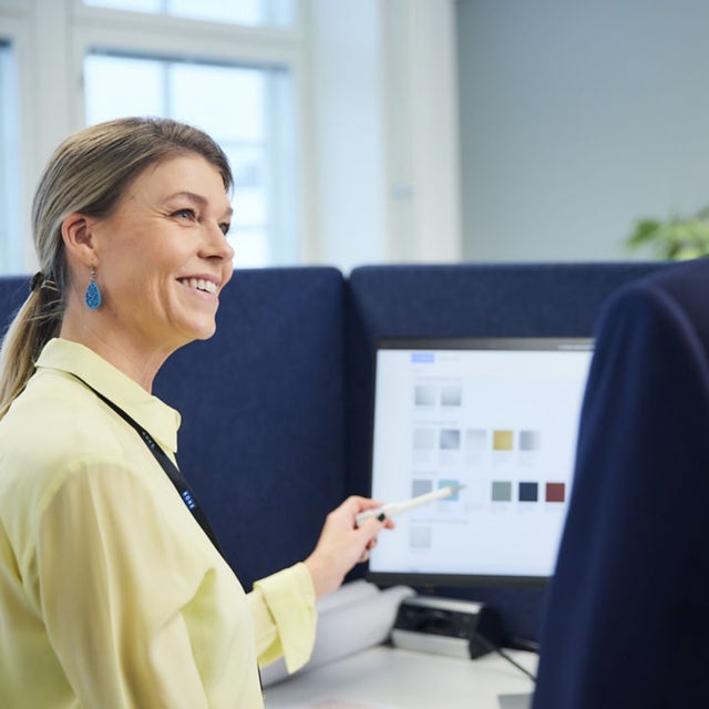 Woman pointing at a screen at an office