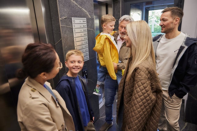 Family standing in front of an elevator.