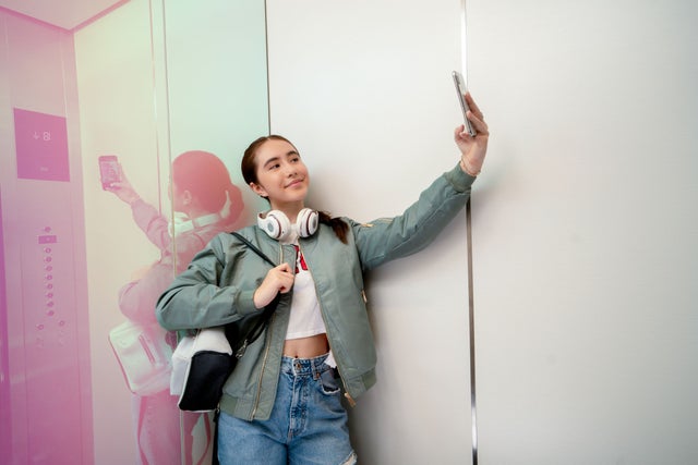 Young woman taking a selfie in an elevator