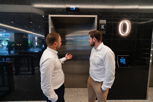 Two men in front of an elevator