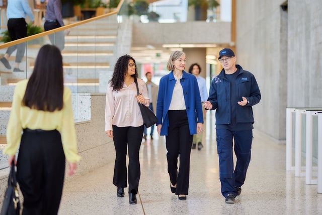 KONE technician with customers walking in a lobby