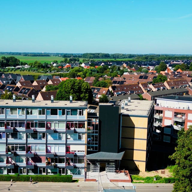 Overview of Leerdam with buildings in front and field at the back.