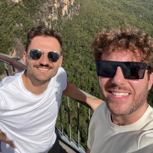 Two men smiling to the camera.