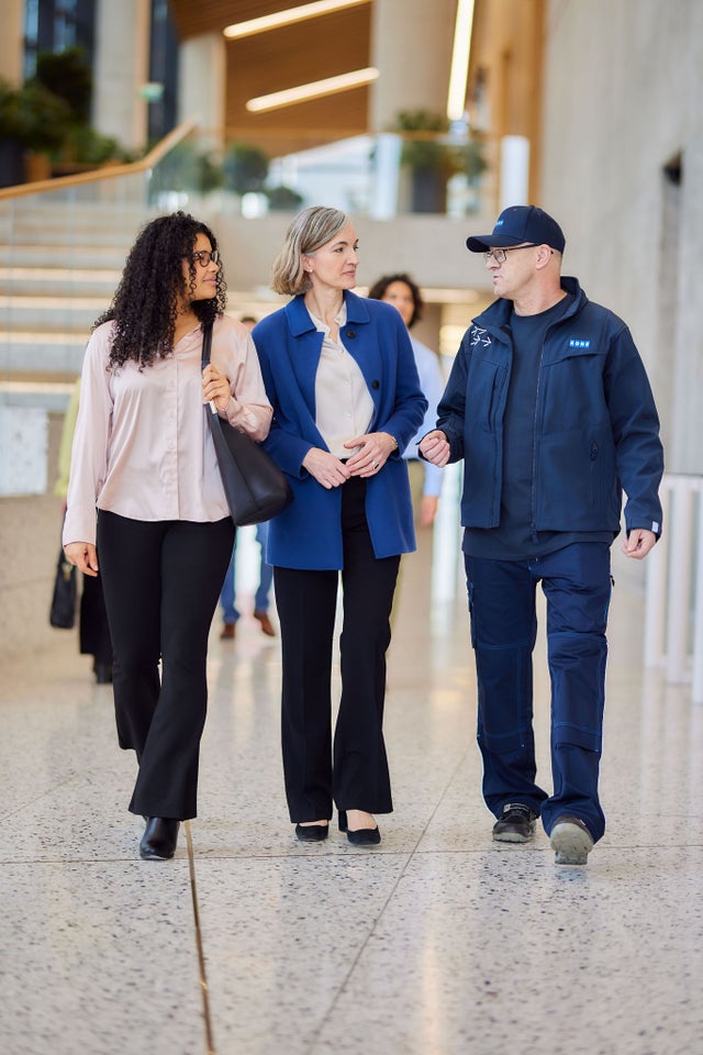 KONE technician walking with customers in lobby