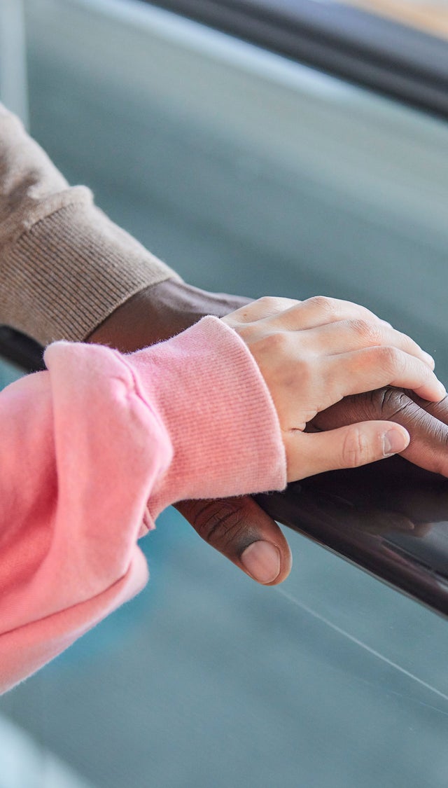Two hands on an escalator handrail