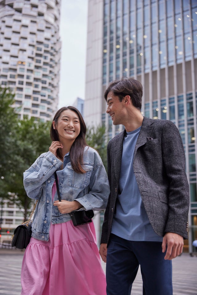 Two people with tall buildings in the background
