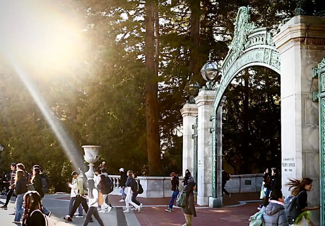 Students walking near a large gate.