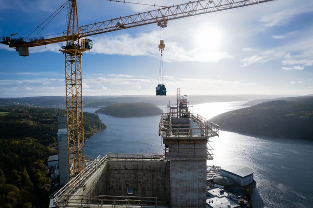 Rakennustyömaa, nosturi ja saarimaisema taustalla