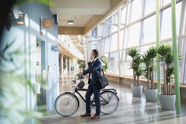 Man with a bicycle talking on a phone.