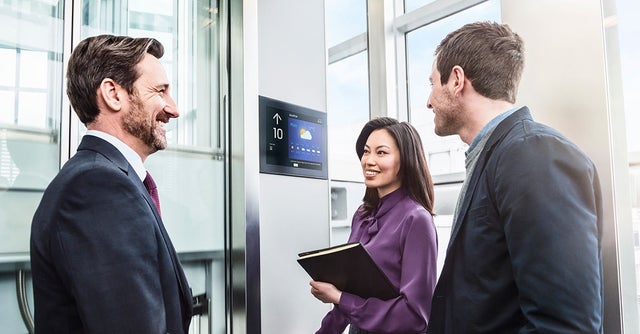 Businesspeople talking in an elevator.