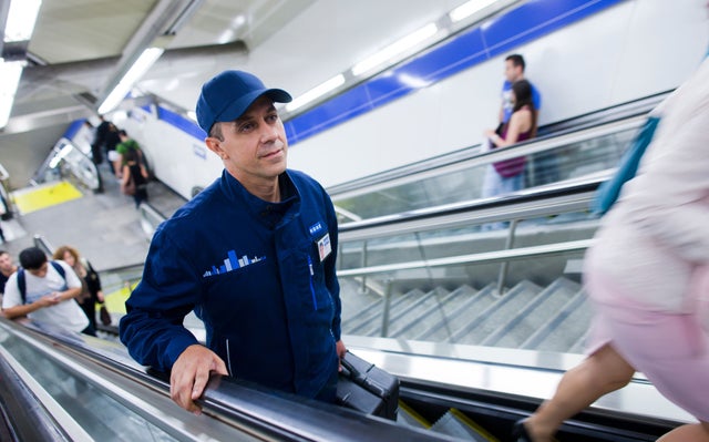 KONe technician travelling on escalator