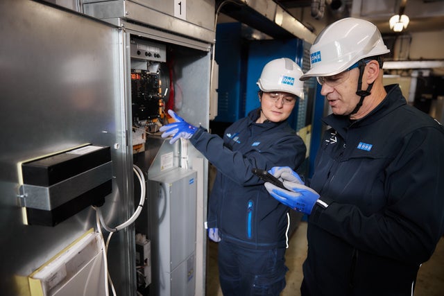 Two KONE technicians working on the elevator equipment.