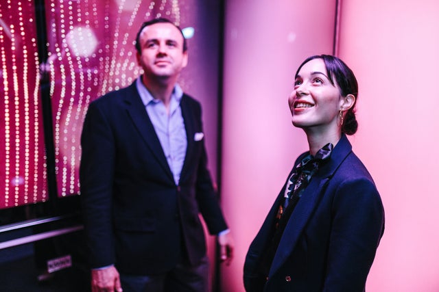 Man and woman in Digital Experience Car elevator with pink design