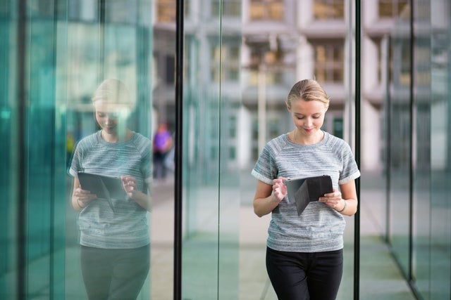 A young woman in an urban environment looking at an ipad
