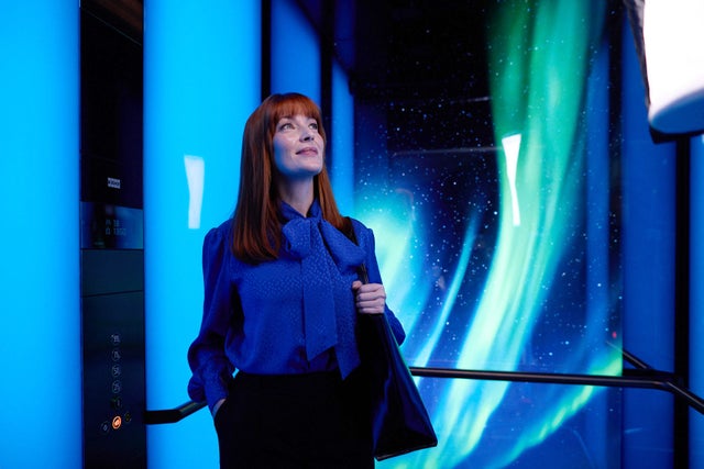 Woman in an elevator with colourful background