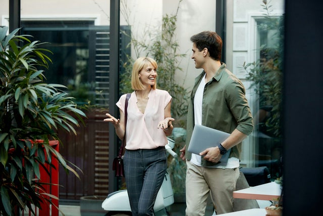 man and woman discussing outside a building